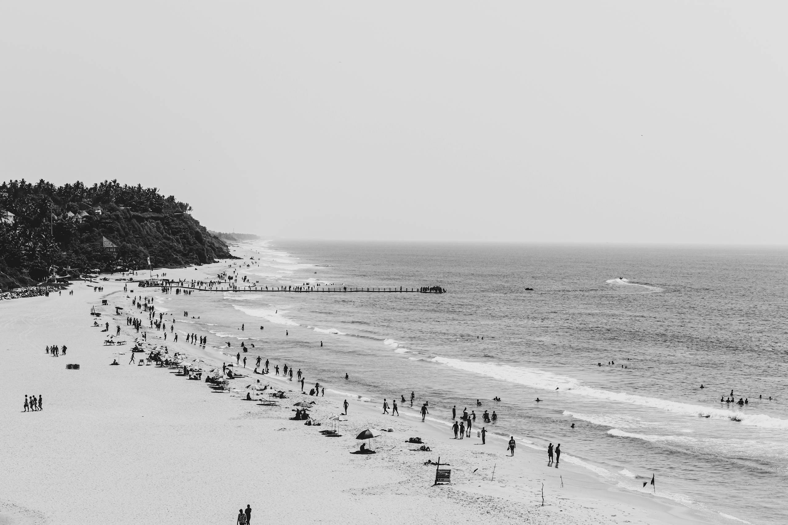 Stunning aerial black and white photograph of Varkala Beach, India, capturing people enjoying the seaside.